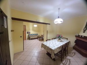 uma sala de jantar com uma mesa e um sofá em B&B A CASA DI MARIO em San Severino Lucano