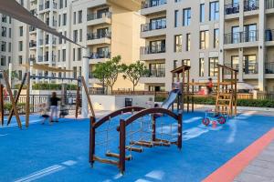 a playground in a city with children playing on it at Frank Porter - Hayat Boulevard 1A in Dubai