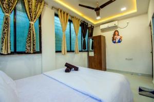 a bedroom with a large white bed with windows at Silver leaf Villa in Lonavala +25 photos
