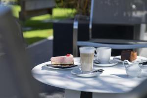 una mesa con dos tazas de café y pasteles. en Boutique Hotel Gams, en Oberstdorf