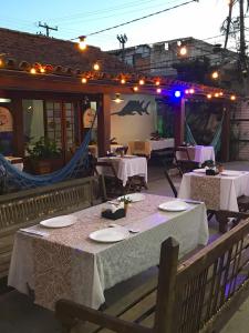 a restaurant with tables with white tablecloths and lights at Pousada Marujos in Búzios +120 photos
