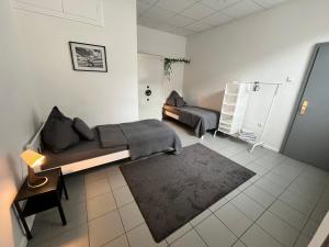een kamer met 2 bedden en een bank. bij Apartment Central 10D 55qm Wi-Fi free Parking calm back house in Dortmund