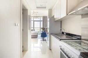 a white kitchen with a sink and a stove at Frank Porter - Carson A in Dubai Marina