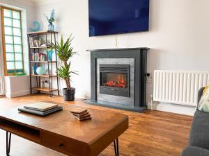 sala de estar con chimenea y mesa de centro en Hydeaway beautiful 3 bedroom house in a great location, en Bournemouth