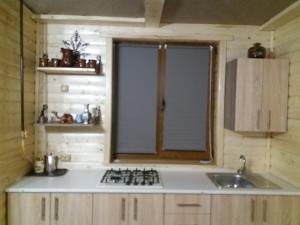 eine Küche mit einem Herd, einem Waschbecken und einem Fenster in der Unterkunft Villa Na uzlissi in Myhowe