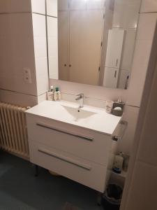 a bathroom with a white sink and a mirror at Chambre Céleste in Tours