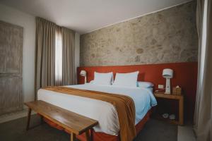 een slaapkamer met een groot bed met een houten hoofdeinde bij Chozos Resort in Agrelo