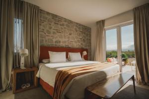 a bedroom with a large bed with a stone wall at Chozos Resort in Agrelo