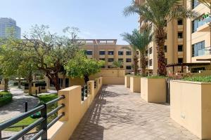 a walkway in front of a building with palm trees at Frank Porter - Al Sidir 2 in Dubai