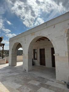 a stone building with two arches on a patio at Asyada Suites Hotel in Nevsehir