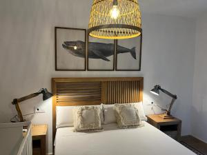 1 dormitorio con 1 cama grande con 2 lámparas y lámpara de araña en Apartamento Plaza San Francisco, en Trujillo