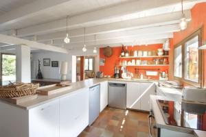 uma cozinha com armários brancos e uma parede laranja em Comfortable family chalet 5 min drive from the lake em Viviers-du-Lac