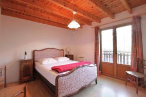 um quarto com uma cama e uma grande janela em Comfortable family chalet 5 min drive from the lake em Viviers-du-Lac