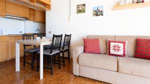 uma sala de estar com uma mesa e um sofá em San Sebastiano 4 em Bormio