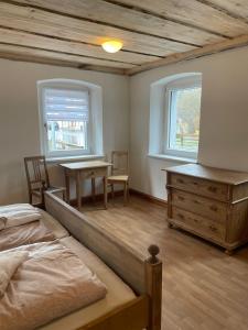 um quarto com uma cama, uma secretária e uma janela em Ferienhaus Linde em Warmensteinach
