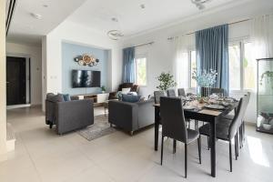 杜拜的住宿－Frank Porter - Serena Casa Viva，用餐室以及带桌椅的起居室。
