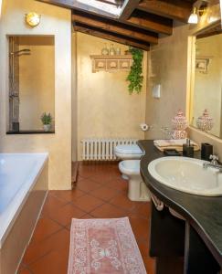 a bathroom with a tub and a toilet and a sink at Dimora Altana in Brescia