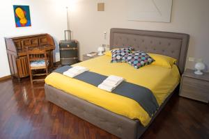 ein Schlafzimmer mit einem großen Bett mit gelber Bettwäsche in der Unterkunft Dimora Altana in Brescia