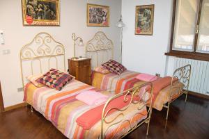 two beds are sitting in a room with at Dimora Altana in Brescia