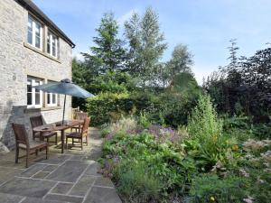 a patio with a table and chairs and a garden at 4 Bed in Brassington 47450 in Brassington