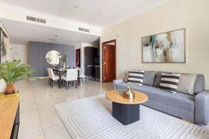 sala de estar con sofá azul y mesa en Frank Porter - Marina Heights 1 en Dubái