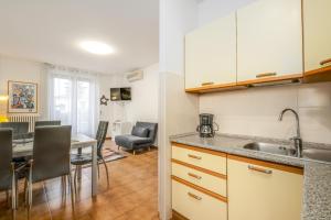 cocina con fregadero y mesa con sillas en Apartment Soleil - Sole del Garda, en Lazise