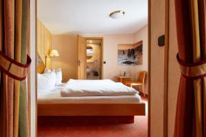 a hotel room with a bed and a door open at Hotel Ladenmühle in Kurort Altenberg