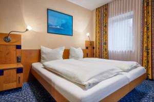 a bedroom with a large white bed in a room at Hotel Ladenmühle in Kurort Altenberg