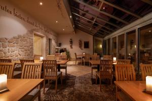 ein Restaurant mit Holztischen und -stühlen und einer Steinmauer in der Unterkunft Hotel Ladenmühle in Kurort Altenberg