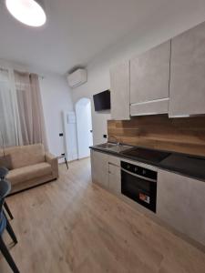 - une cuisine avec une cuisinière et un canapé dans la chambre dans l'établissement ARI'S HOME, à La Spezia