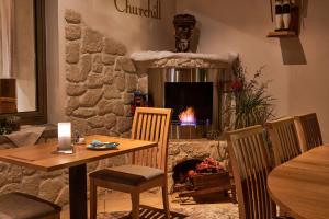 een eetkamer met een tafel en een open haard bij Hotel Ladenmühle in Kurort Altenberg