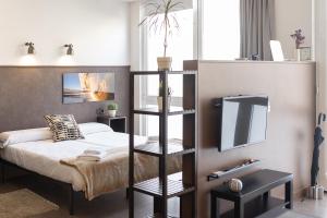 ein Schlafzimmer mit einem Bett und einem TV auf einem Regal in der Unterkunft Apartamentos Salbide Zarautz in Zarautz