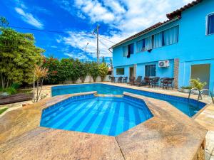 a swimming pool in front of a house at IBELLO BEACH Pousada in Cabo Frio