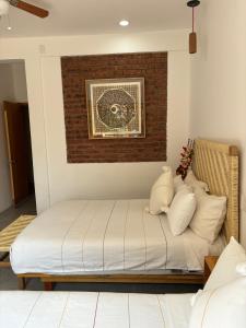 a bed in a room with a brick wall at Santa Cecilia Hotel in Oaxaca City