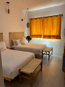 a hotel room with two beds and a window at Santa Cecilia Hotel in Oaxaca City