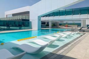 een zwembad met een rij stoelen in een gebouw bij Frank Porter - 1 Residences 2 East Tower in Dubai