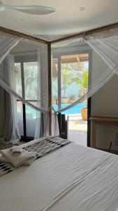 a bedroom with a bed with a view of a pool at Villa Chanalu in Ngaparou