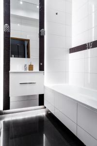 uma casa de banho branca com uma banheira e um lavatório em Househost Apartment: Józefa 2/10 em Cracóvia