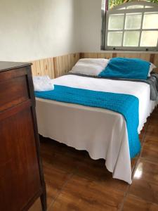 Una cama con una manta azul encima. en Casa do Chá Ouro Preto en Ouro Preto