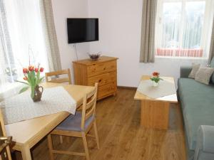 a living room with a table and a couch at MINERVA in Špindlerův Mlýn