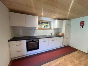 een keuken met witte kasten en een fornuis met oven bij Haus Lechner in Gaschurn