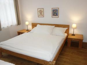 a bedroom with a large white bed with two lamps at MINERVA in Špindlerův Mlýn