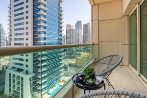 a balcony with two chairs and a view of a city at Frank Porter - Royal Oceanic in Dubai