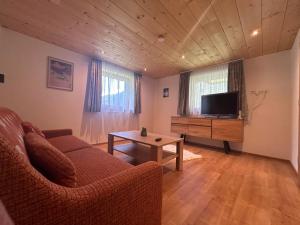 een woonkamer met een bank en een tv bij Haus Lechner in Gaschurn