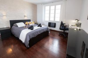 a bedroom with a bed and a desk and a television at Cosy Paris - Disneyland - RER A in Fontenay-sous-Bois