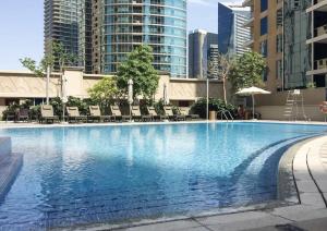 a large swimming pool with chairs and buildings at Frank Porter - Beauport in Dubai