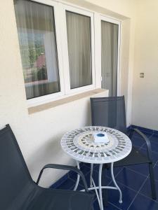 einen Tisch und zwei Stühle auf dem Balkon in der Unterkunft Casa Liana in Buşteni