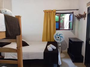 a bedroom with a bed and a window and a fan at SANTANDER ALEMAN HOSTEL in San Gil