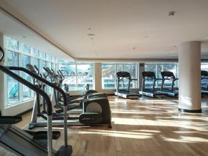 a gym with a row of treadmills in a building at Frank Porter - Al Majara in Dubai