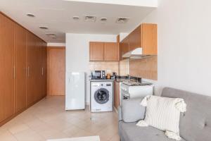 a kitchen with a couch and a washer and dryer at Frank Porter - Lago Vista in Dubai